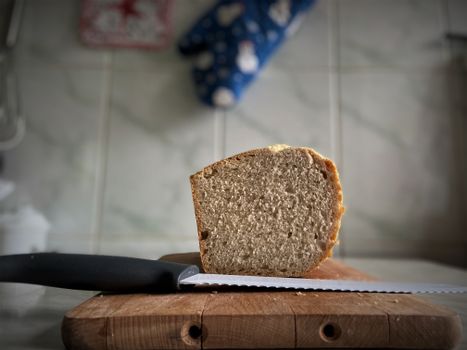 Close-up of a sliced loaf on a wooden board with a knife, ideal for food photography.