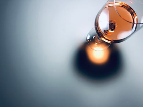 Elegant close-up of a half-full wine glass casting a shadow, perfect for beverage and lifestyle themes.