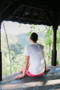 男人坐在露台上，欣赏着户外宁静环境中风景秀丽的山谷景色