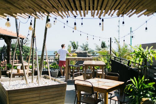 Faceless man leaning on railing in cafe