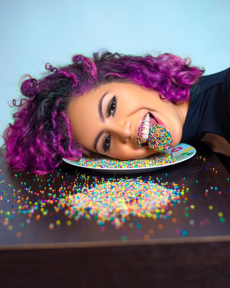 Emotional woman with sprinkles on tongue