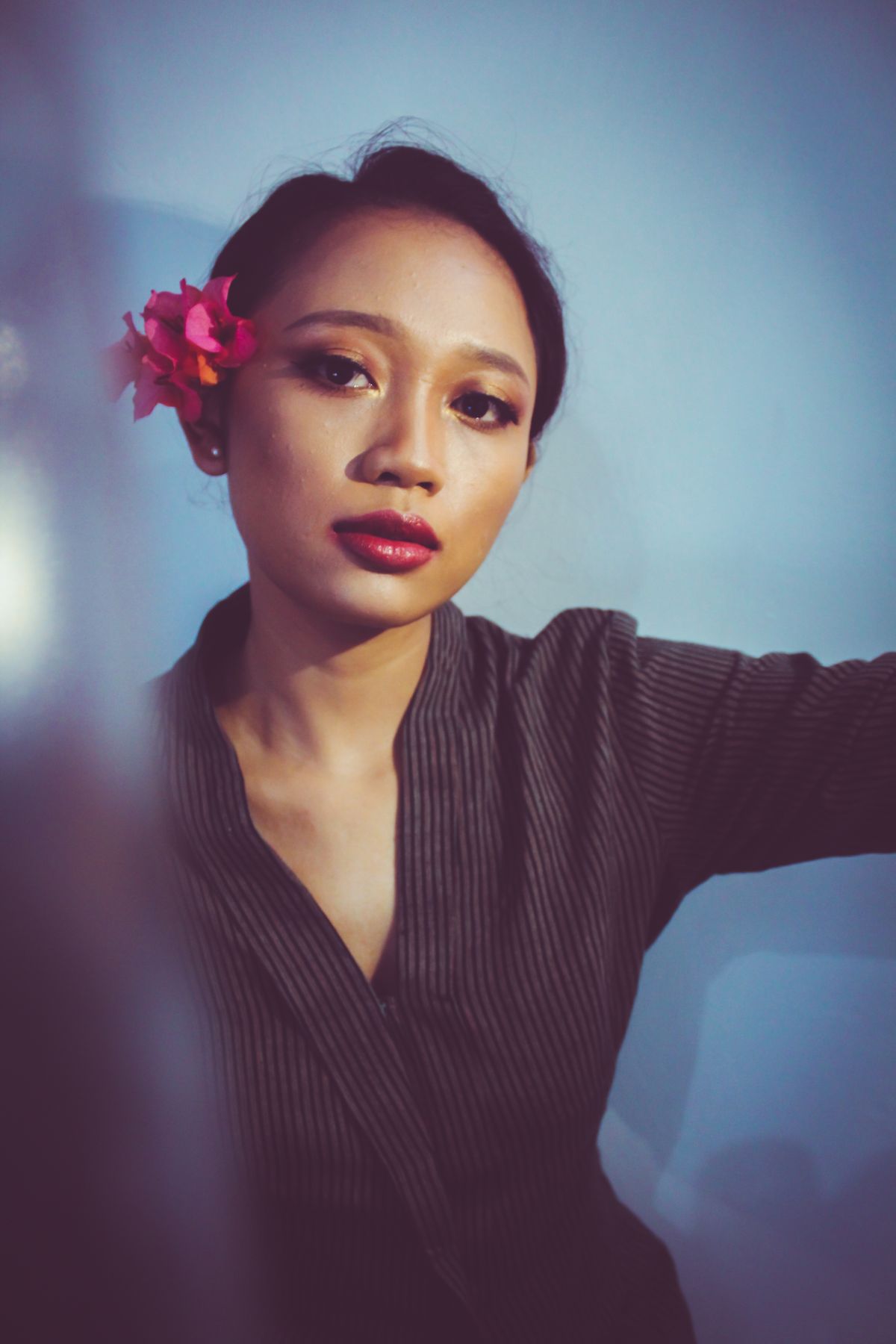 Editorial portrait of a woman with a flower