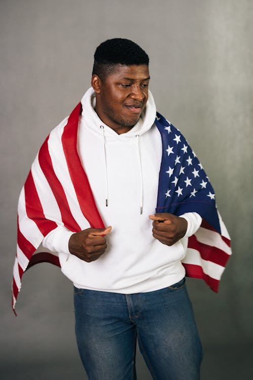 Studio Shot of a Man in a Hoodie with a Flag on His Back