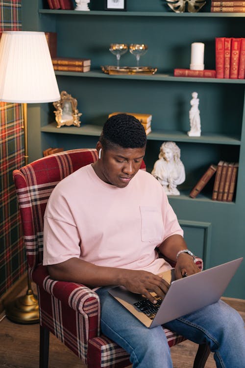 Man in a Pink Shirt Working on His Laptop