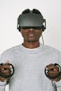 A Man in Gray Sweater Enjoying the VR Headset he is Playing