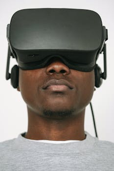 Close-up of a man wearing VR glasses, focused on virtual reality experience indoors.