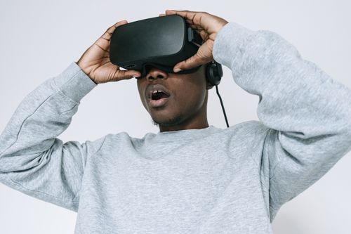 Free Black man wearing VR glasses showing amazement on white background. Stock Photo