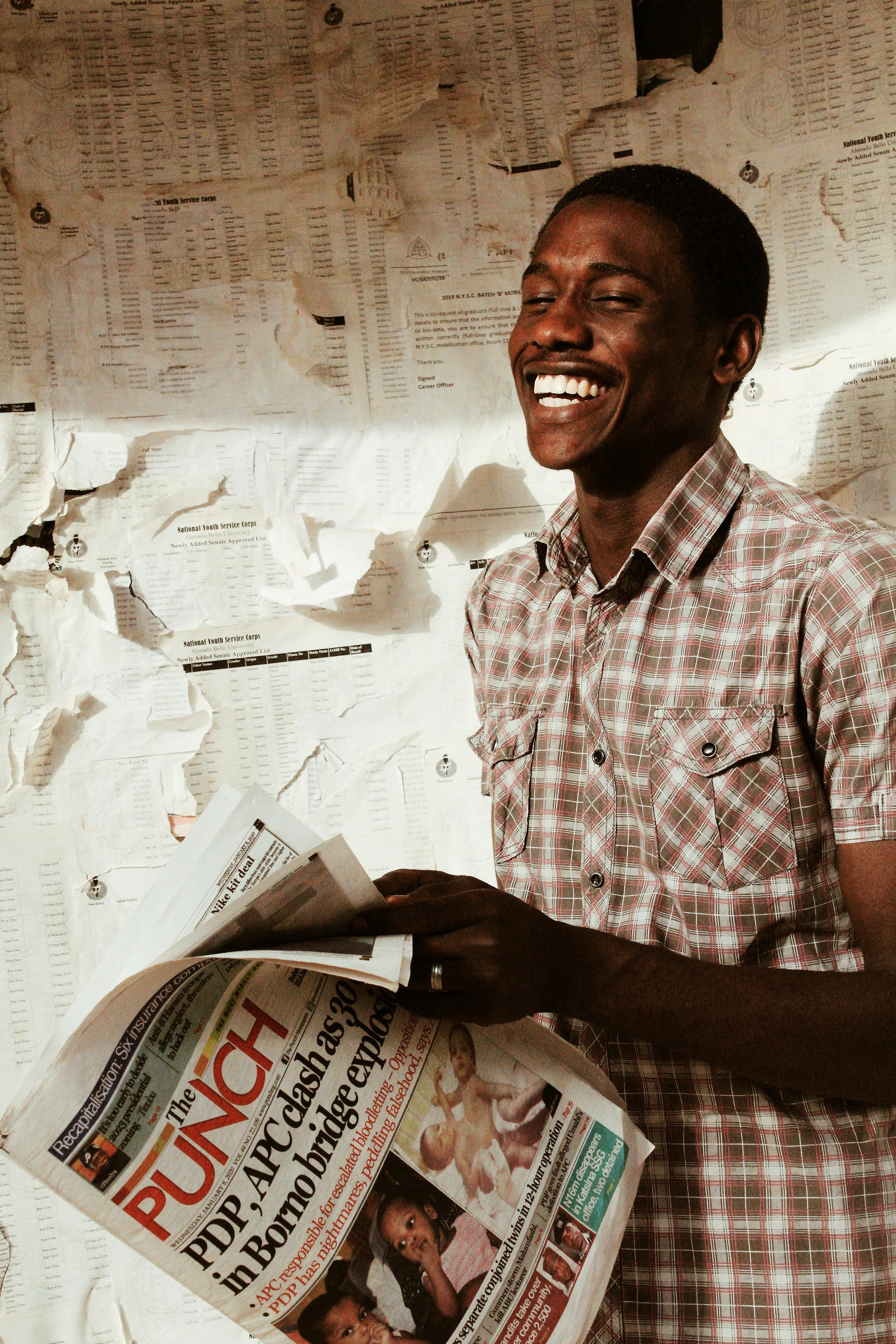 happy black man with newspaper in hand