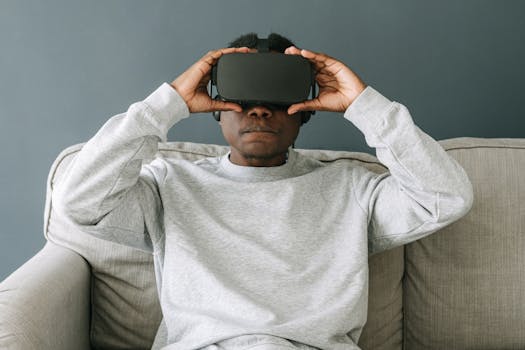 A man in a gray sweater enjoying virtual reality with a VR headset indoors.