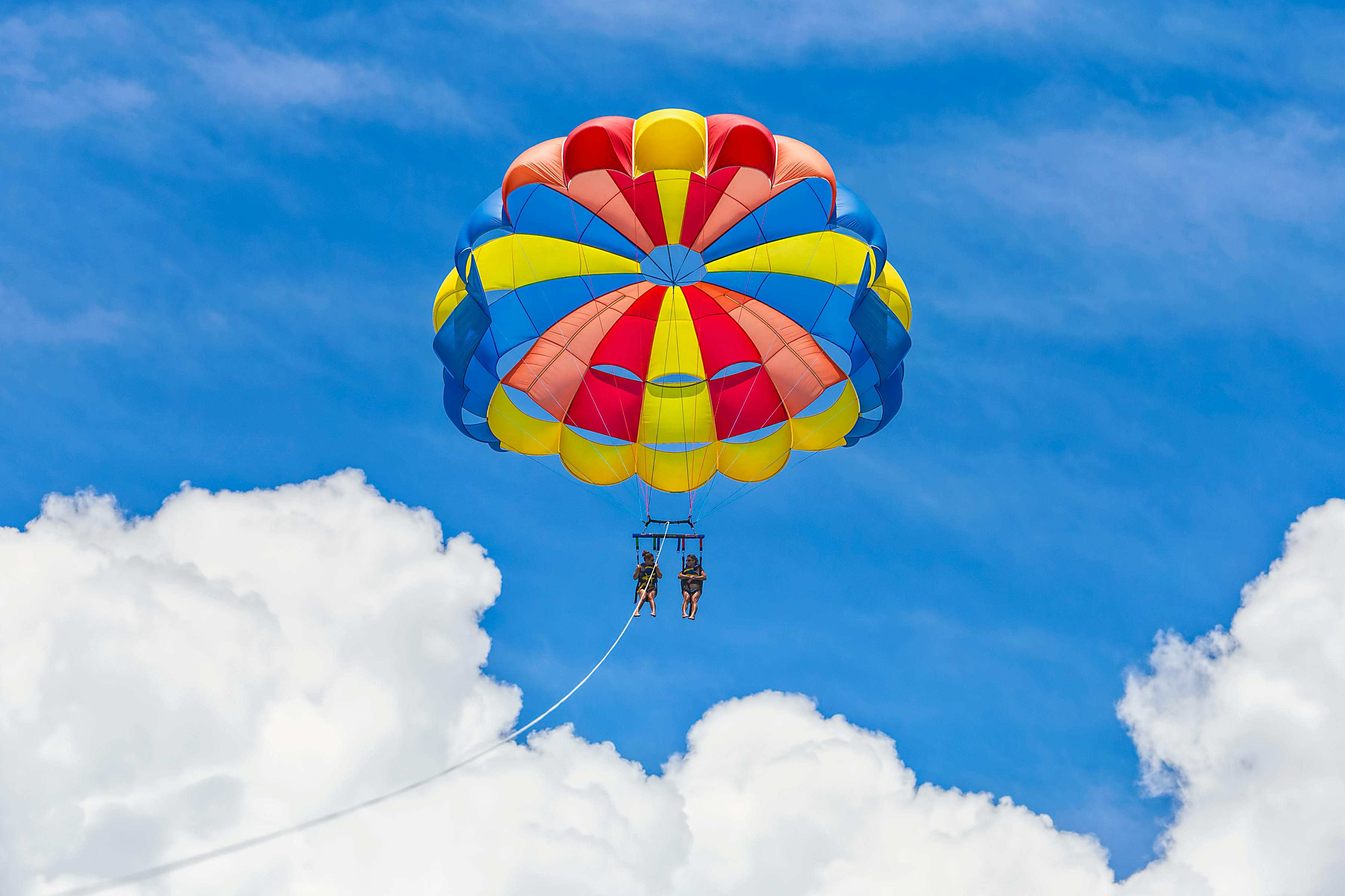 Yellow Red and Blue Parachute in Mid Air Under Blue Sky