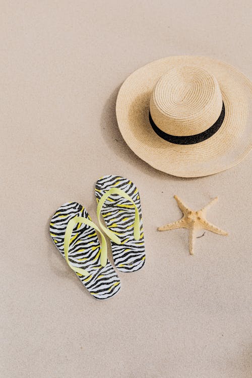 Beach Hat Flip Flops and a Starfish on the Sand