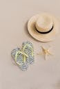 一个简约的夏季海滩设置具有帽子，人字拖，和沙滩上的海星