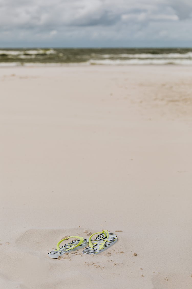 A Pair Of Flip Flops On The Sand