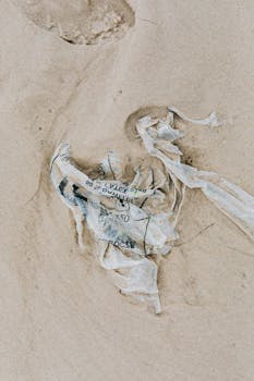 Plastic waste littering a sandy beach, highlighting pollution concerns.