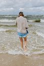 夏天，一个女人在海滩上散步，享受着被海浪包围的宁静