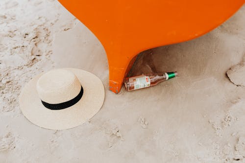 Sun Hat and Beer on Beach Sand