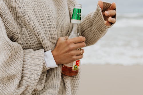 Person in Beige Sweater Holding a Beer