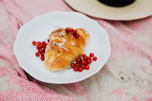 Croissant and Currants on White Ceramic Plate 