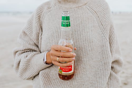 Woman in Sweater Holding a Beer Bottle