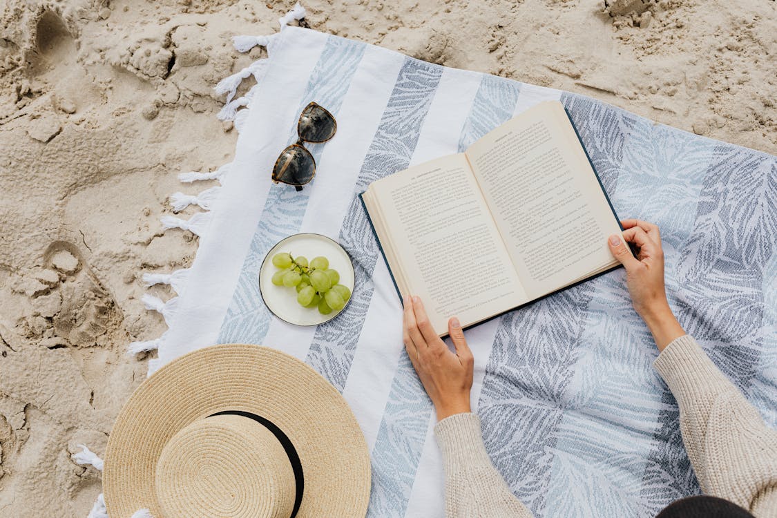 Free Reading a Book at the Beach Stock Photo