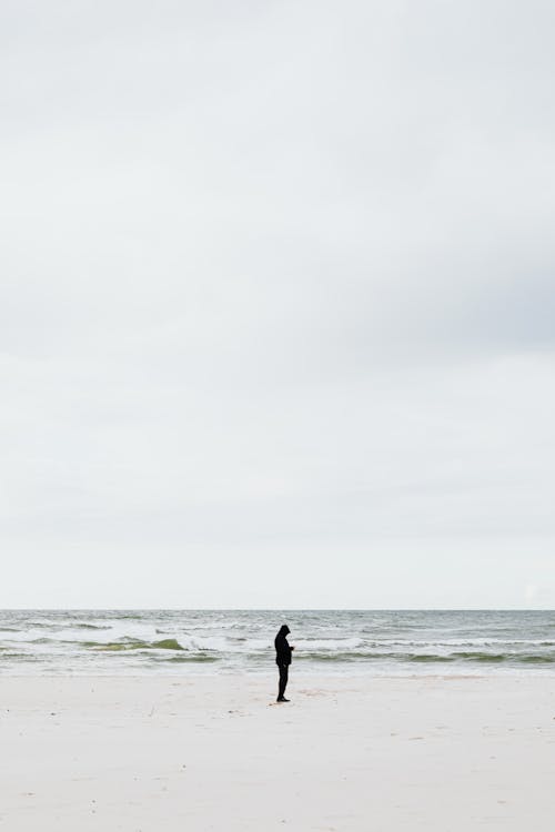 Free Photo of a Person Standing at the Beach Stock Photo