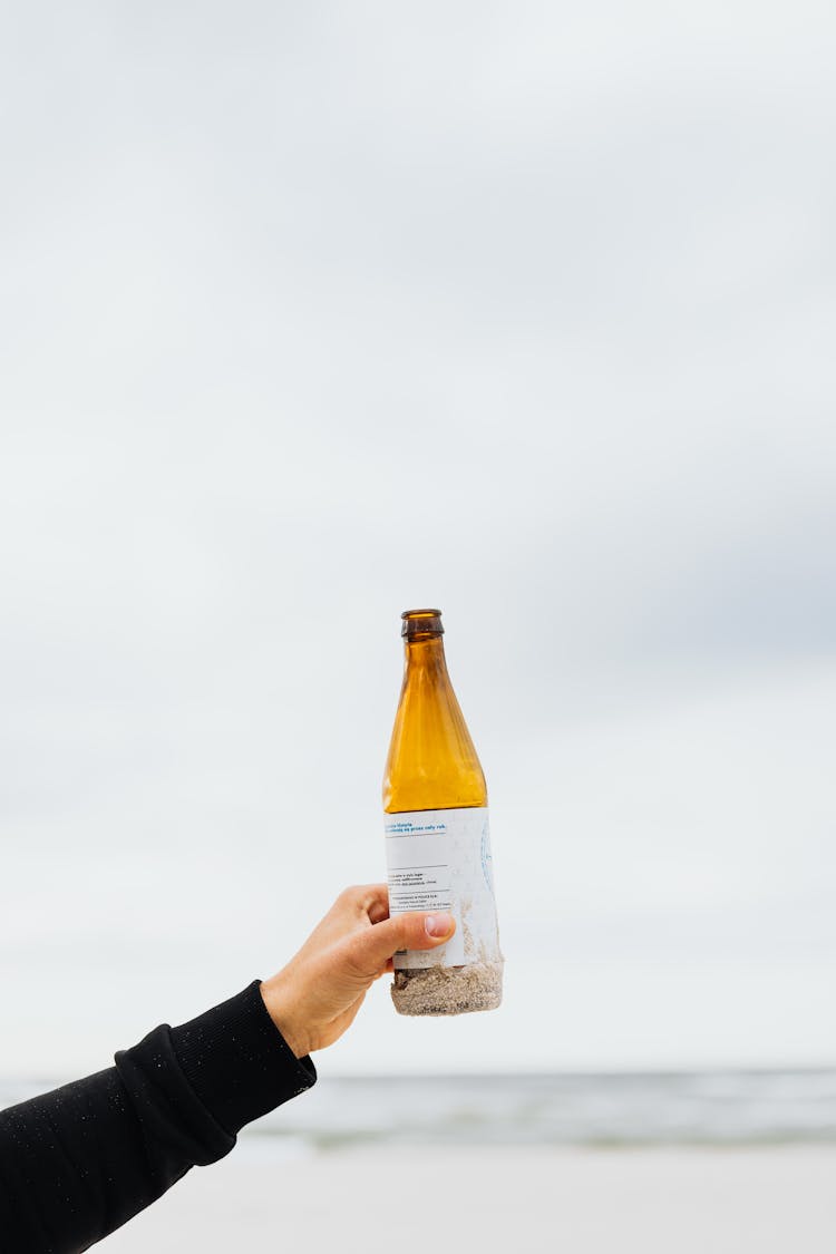 Photo Of A Person's Hand Holding A Beer Bottle