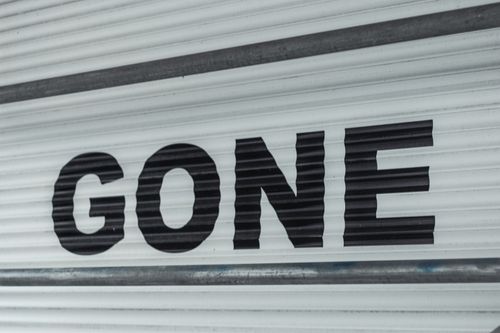 Free Close-up of a corrugated steel shutter with bold black 'Gone' text, providing a minimalist industrial vibe. Stock Photo