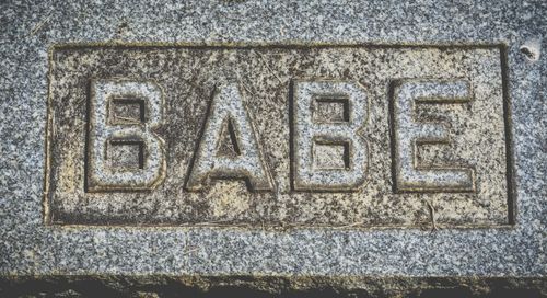 Free Top view of engraved word babe in capital letters on granite rough stone block Stock Photo
