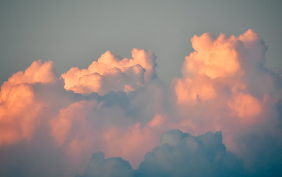 Fluffy cumulus clouds in gray sky on sunrise