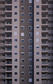 Facade of multistory symmetrical house with balconies and windows in city street in daylight with modern architecture in downtown outside