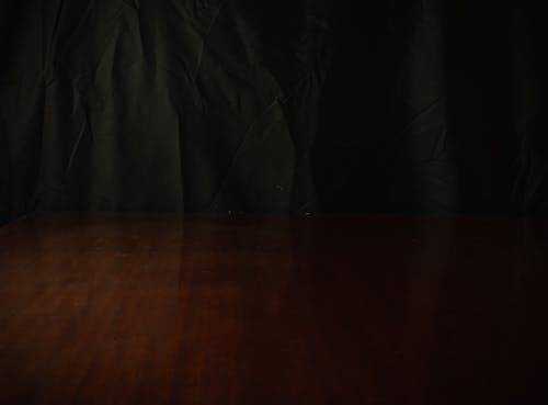 Black Textile on Brown Wooden Surface