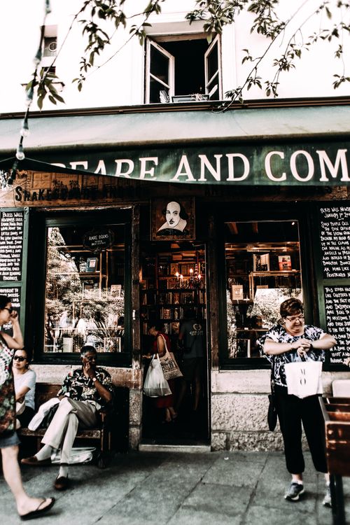 Free Multiethnic people near entrance of old shop with glass cases in city at daytime Stock Photo