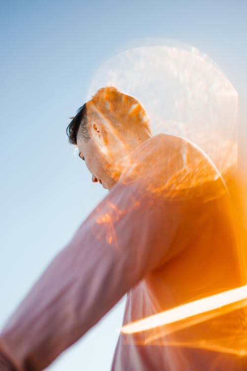 Young man against blue sky in sunlight