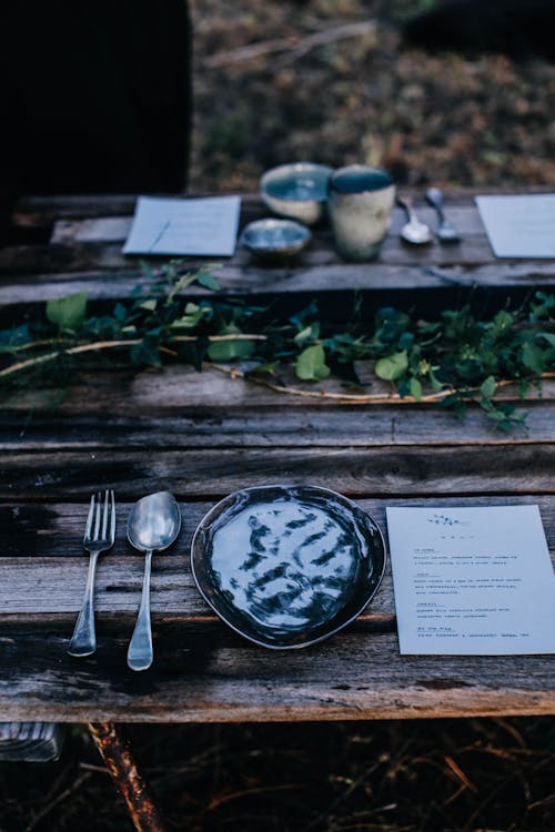 Table setting on shabby wooden table in woodland