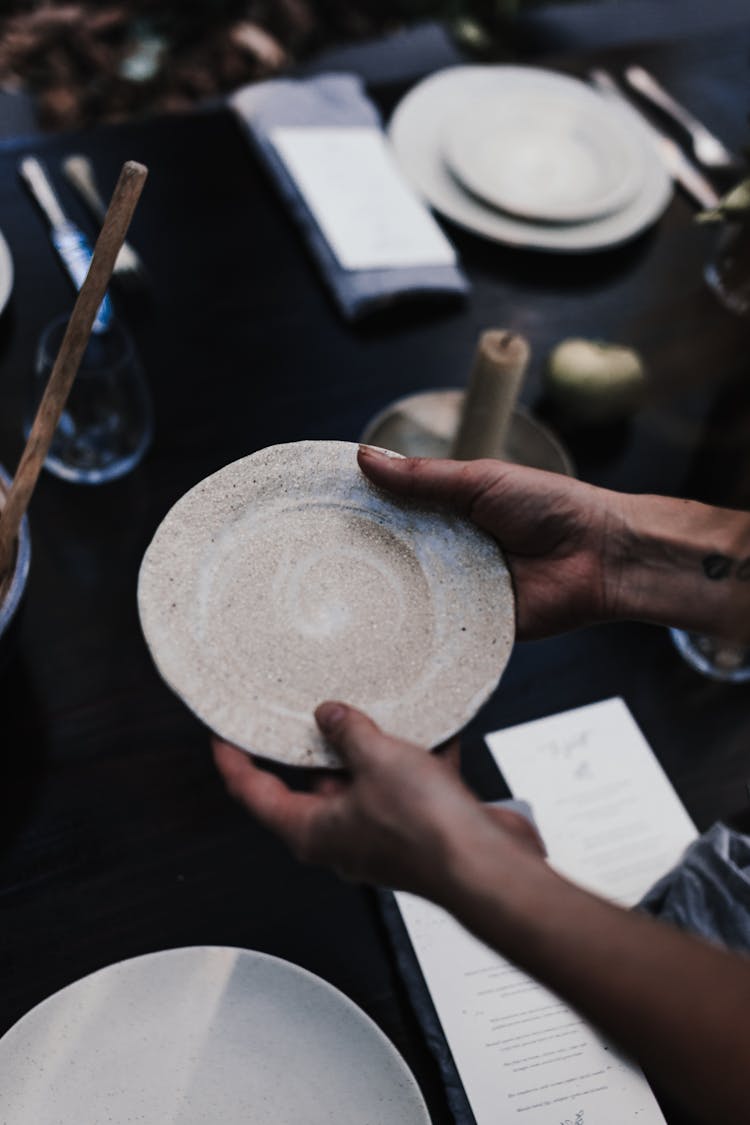 Crop Person With Plate Above Served Table