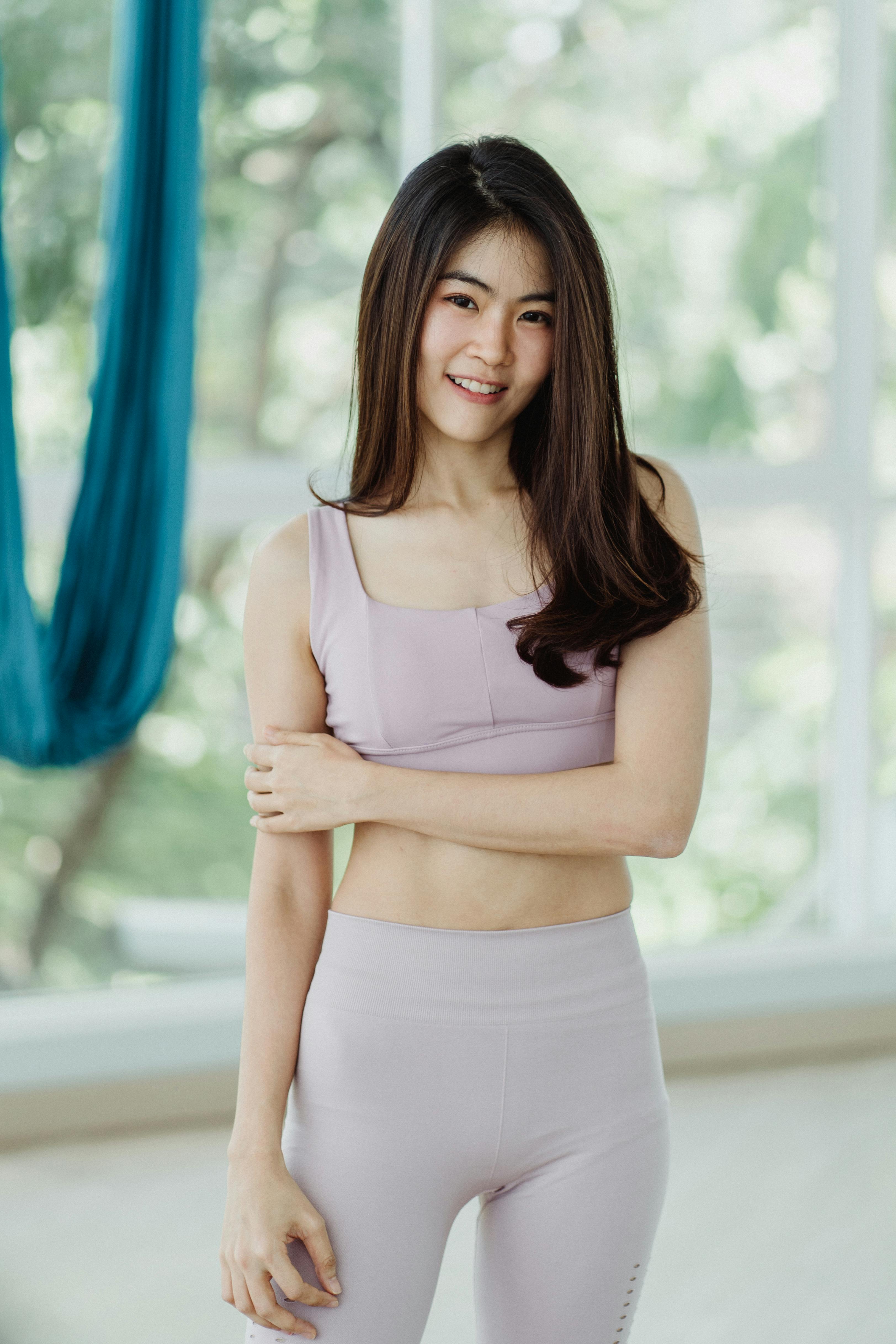 一位穿着运动服、面带微笑的女子肖像，在自然光下立于室内