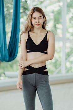 Portrait of a fit woman in sportswear standing indoors, promoting a healthy lifestyle.