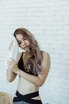 Woman relaxing after workout, using towel. Indoor setting.