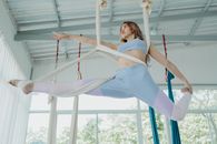 Woman in White Tank Top and Blue Pants Sitting on White Metal Frame