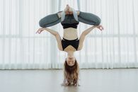 Woman in Black Sports Bra and Gray Sweatpants Doing Yoga