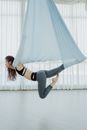 Woman in White Tank Top and Gray Leggings Sitting on White Textile