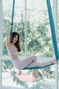 Woman in White Tank Top and White Pants Sitting on Blue Hammock