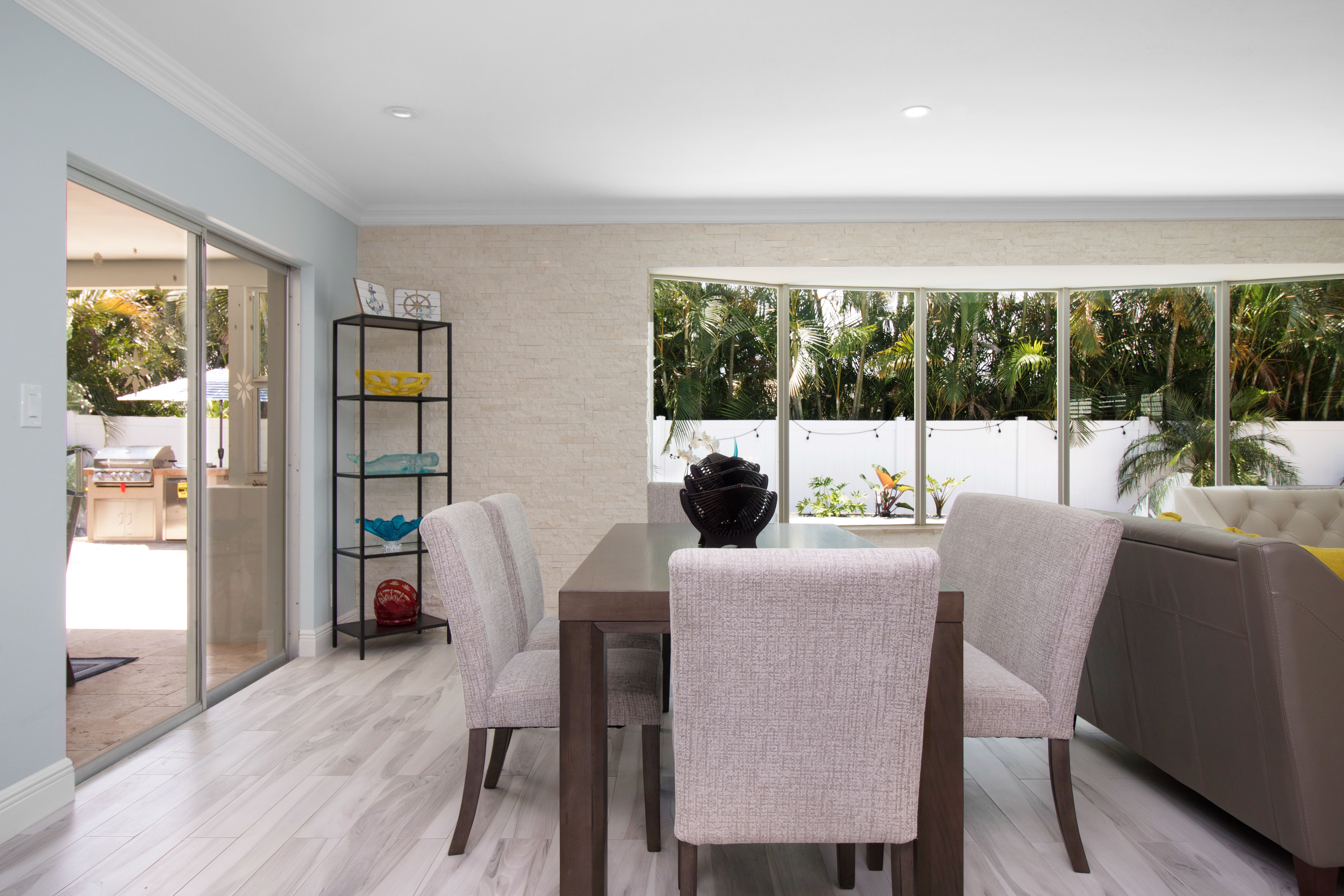 Bright contemporary dining area with minimalist decor and large windows facing a lush garden.