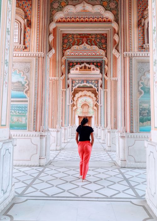 Free A woman walks through an intricately designed corridor showcasing Indian architecture. Stock Photo