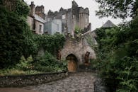 郁郁葱葱的常春藤和石道环绕着迷人的中世纪城堡入口，散发着历史的魅力