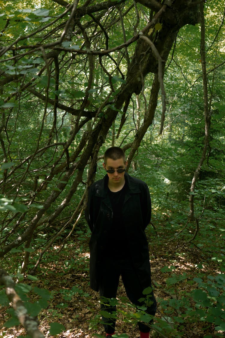 Trendy Man In Black Apparel Walking In Forest