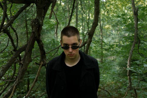 Trendy man in sunglasses in summer forest