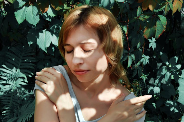 Young Woman Enjoying Summer Day In Garden