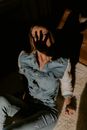 白天，一位穿着牛仔布的时尚女性在室内开玩笑地投下阴影