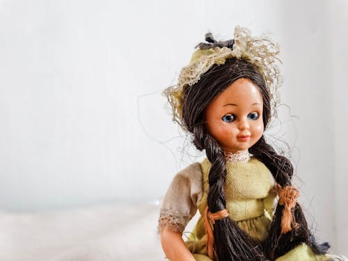 Close-Up Shot of a Girl Doll on White Background